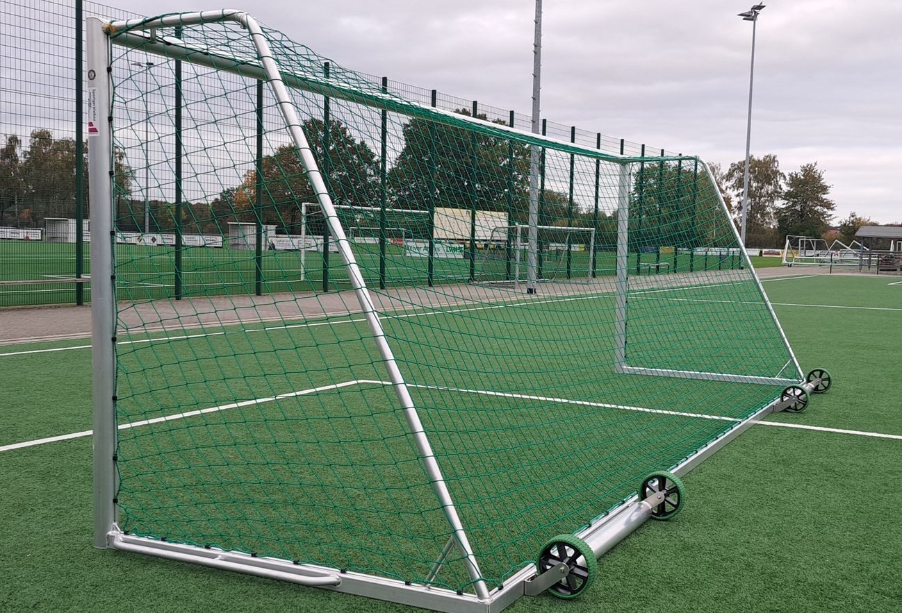 Großfeld-Fußballtor Standard aus Aluminium in Schrägansicht mit Transportrollen auf Kunstrasenplatz