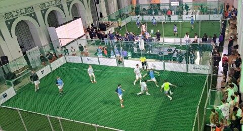 Mobiler Soccer Court aus Aluminium in einer Veranstaltungshalle, Spielbetrieb bei Turnier, Vogelperspektive, grünes Netz