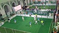 Mobile Soccer Courts mieten, Aluminium-Bandensystem, DIN EN 15312, Soccer Eventsport Mobiler Soccer Court aus Aluminium in einer Veranstaltungshalle, Spielbetrieb bei Turnier, Vogelperspektive, grünes Netz