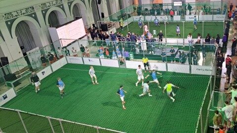 Mobile Soccer Courts mieten, Aluminium-Bandensystem, DIN EN 15312, Soccer Eventsport Mobiler Soccer Court aus Aluminium in einer Veranstaltungshalle, Spielbetrieb bei Turnier, Vogelperspektive, grünes Netz