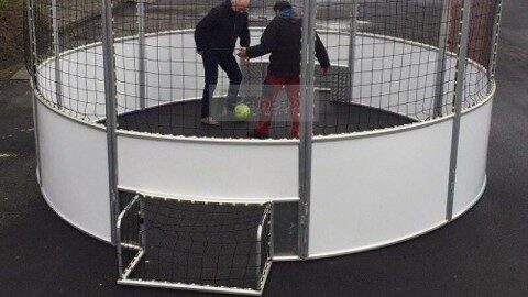 Soccer Cage rund 5 m mieten, Aluminium, Soccer Eventsport Runder Soccer Cage mit 5 m Durchmesser aus Aluminium, weiße Banden, umlaufendes Netz, zwei Spieler im Einsatz, Außenbereich