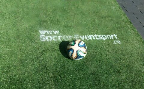 Fußball auf Kunstrasen mit eingeblendeter Website-Adresse www.soccer-eventsport.de