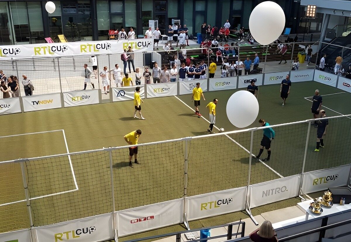 Fußballturnier auf einem Soccer Court beim RTL Cup, Vogelperspektive mit vielen Zuschauern und professionellem Branding