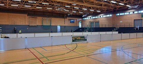 Nahansicht aufgebauter mobiler Banden von Soccer Eventsport in Sporthalle Osnabrück, Soccer Eventsport Logo auf Bandenwerbung, Kinder spielen im Hintergrund